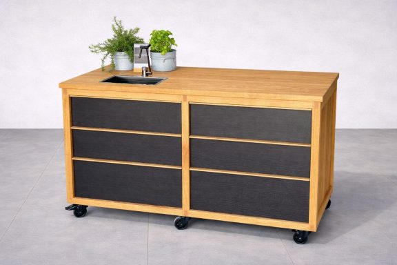 Holztisch mit vier Schubladen und zwei Pflanzen auf der Oberfläche, auf Rollen.